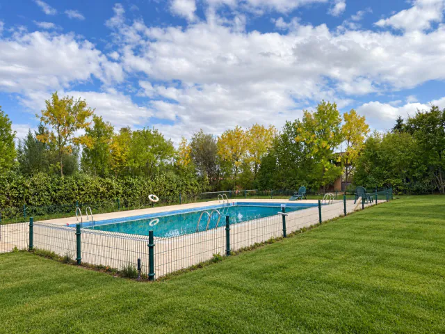 La piscina exterior, con el césped alrededor